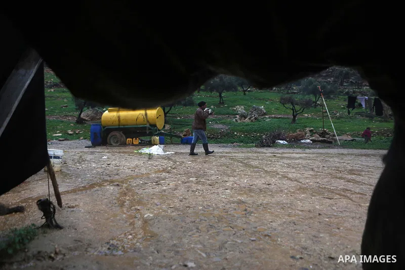 A Palestinian Bedouin man crosses a road flooded during a rainy day in the village of Ein Qiniya near the West Bank city of Ramallah, Jan. 25, 2016. Photo by Shadi Hatem