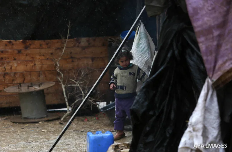A Palestinian Bedouin girl stands next to her family's flooded tent during a rainy day in the village of Ein Qiniya near the West Bank city of Ramallah, Jan. 25, 2016. Photo by Shadi Hatem