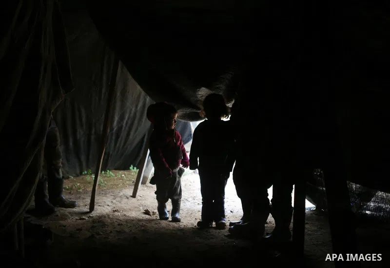 Palestinian Bedouin children sit inside their family's tent during a rainy day in the village of Ein Qiniya near the West Bank city of Ramallah, Jan. 25, 2016. Photo by Shadi Hatem