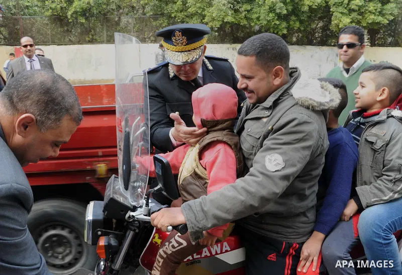 Egyptian policemen give out chocolates to citizens on Cairo's landmark Tahrir Square on January 25, 2016, as the country marks the fifth anniversary of the 2011 uprising. Egyptians marked the fifth anniversary of the upr...