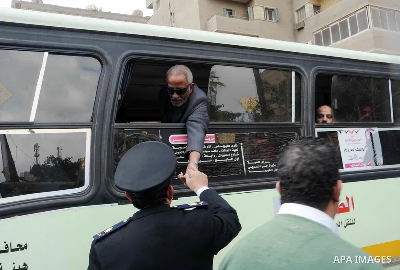 Egyptian policemen give out chocolates to citizens on Cairo's landmark Tahrir Square on January 25, 2016, as the country marks the fifth anniversary of the 2011 uprising. Egyptians marked the fifth anniversary of the upr...