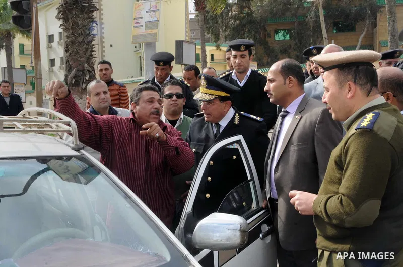 Egyptian policemen give out chocolates to citizens on Cairo's landmark Tahrir Square on January 25, 2016, as the country marks the fifth anniversary of the 2011 uprising. Egyptians marked the fifth anniversary of the upr...