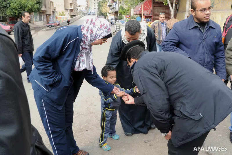 Egyptian policemen give out chocolates to citizens on Cairo's landmark Tahrir Square on January 25, 2016, as the country marks the fifth anniversary of the 2011 uprising. Egyptians marked the fifth anniversary of the upr...