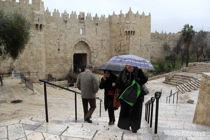 Palestinians walk in front of Damascus gate on a rainy day in Jerusalem's Old city, on Jan. 25, 2016. Photo by Mahfouz Abu Turk
