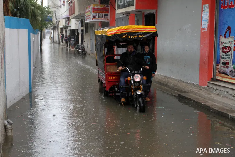 A Palestinian man rides a Tuk-Tuk as he crosses a road flooded with rainwater following heavy rains, in Rafah in the southern Gaza Strip January 25, 2016. Photo by Abed Rahim Khatib