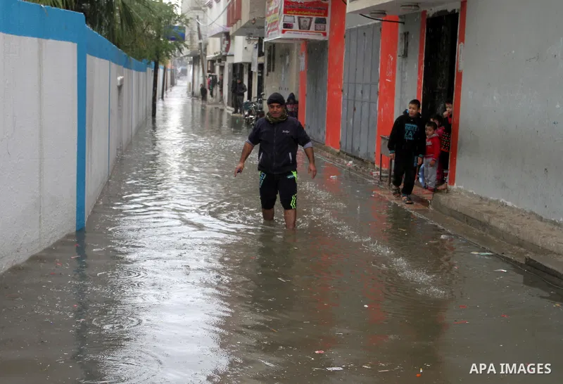 A Palestinian man crosses a road flooded with rainwater following heavy rains, in Rafah in the southern Gaza Strip January 25, 2016. Photo by Abed Rahim Khatib