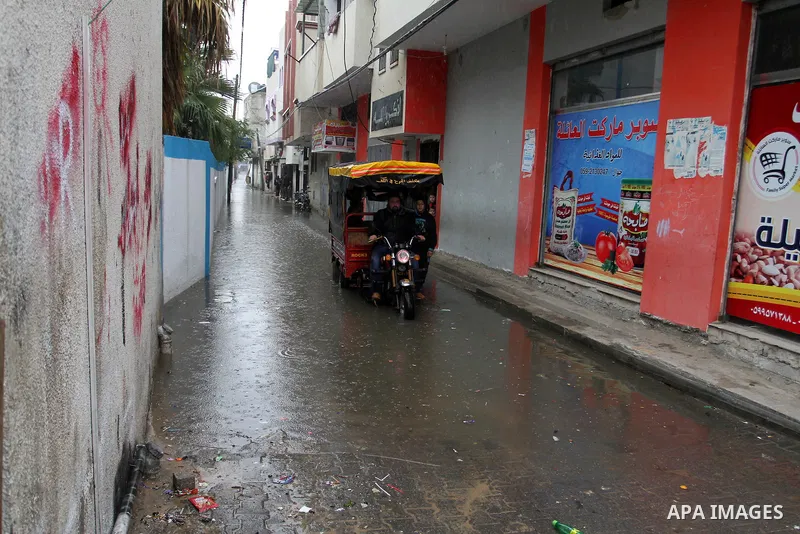 A Palestinian man rides a Tuk-Tuk as he crosses a road flooded with rainwater following heavy rains, in Rafah in the southern Gaza Strip January 25, 2016. Photo by Abed Rahim Khatib