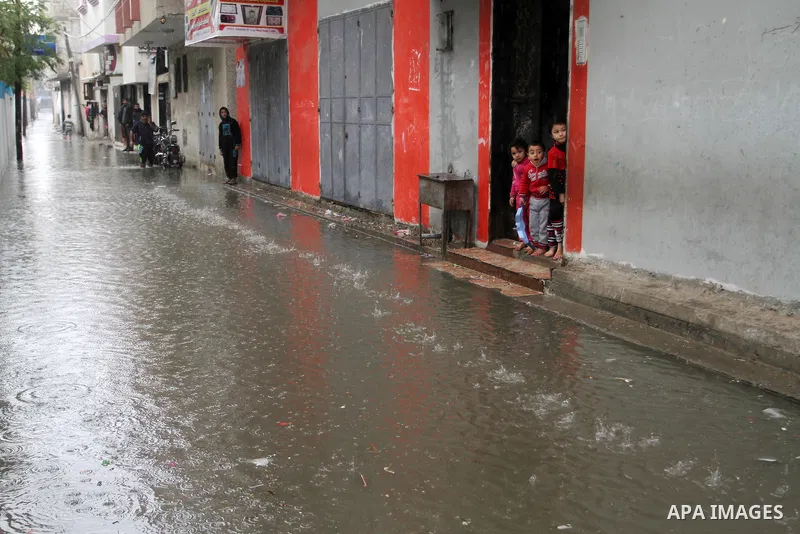 Palestinian children stand outside their family's house on a rainy day in Rafah in the southern Gaza Strip January 25, 2016. Photo by Abed Rahim Khatib