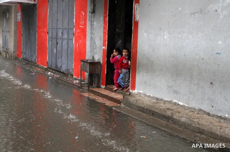 Palestinian children stand outside their family's house on a rainy day in Rafah in the southern Gaza Strip January 25, 2016. Photo by Abed Rahim Khatib