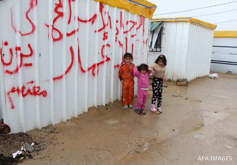 Palestinian children walk past temporary housing during a winter storm in the southern Gaza Strip town of Khan Younis on January 25, 2016. Photo by Abed Rahim Khatib