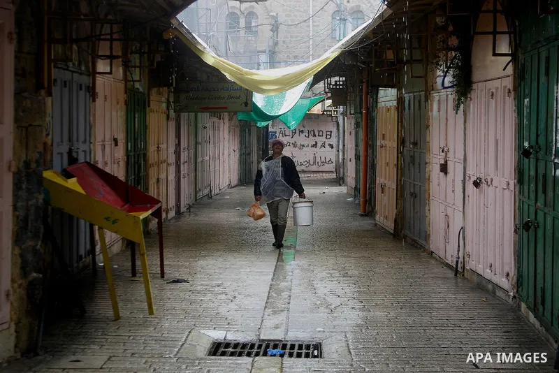 Palestinians walk during a snowstorm in the West Bank city of Hebron, on January 26, 2016. Photo by Wisam Hashlamoun