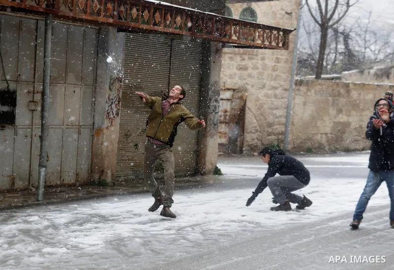 Israeli security forces play with snow during a snowstorm in the West Bank city of Hebron, on January 26, 2016. Photo by Wisam Hashlamoun