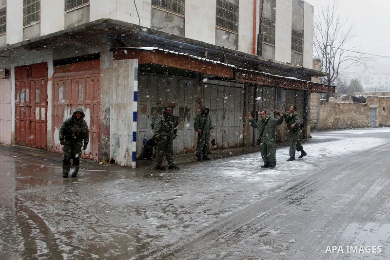 Israeli security forces play with snow during a snowstorm in the West Bank city of Hebron, on January 26, 2016. Photo by Wisam Hashlamoun