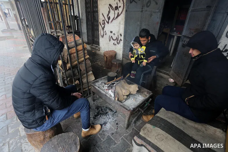 Palestinians warm themselves next to a fire during a winter storm in Gaza city on Jan. 26, 2016. Photo by Mohammed Asad