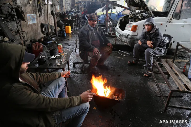 Palestinians warm themselves next to a fire during a winter storm in Gaza city on Jan. 26, 2016. Photo by Mohammed Asad
