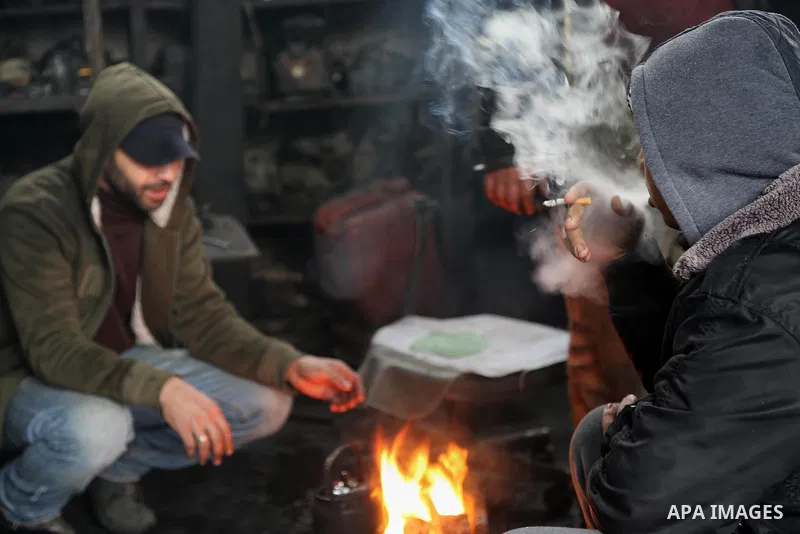 Palestinians warm themselves next to a fire during a winter storm in Gaza city on Jan. 26, 2016. Photo by Mohammed Asad