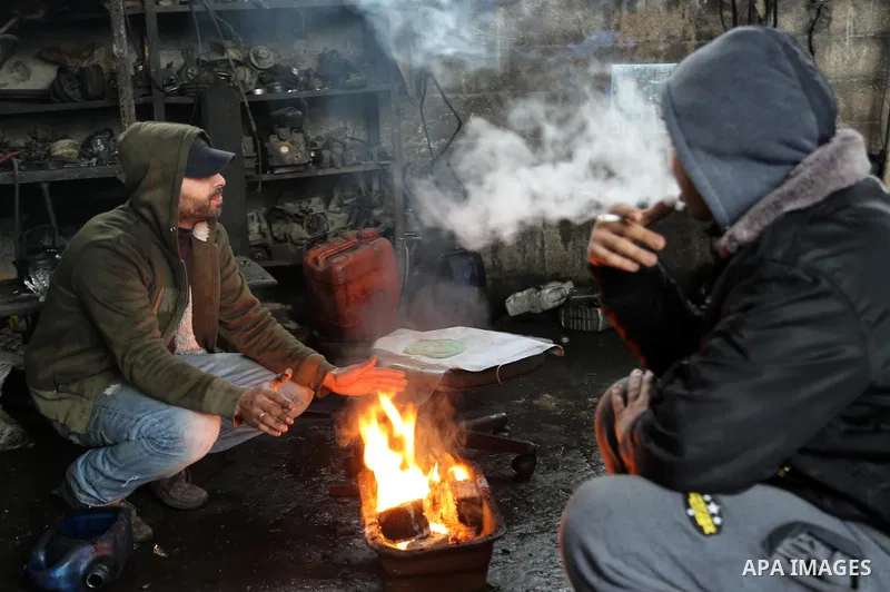 Palestinians warm themselves next to a fire during a winter storm in Gaza city on Jan. 26, 2016. Photo by Mohammed Asad