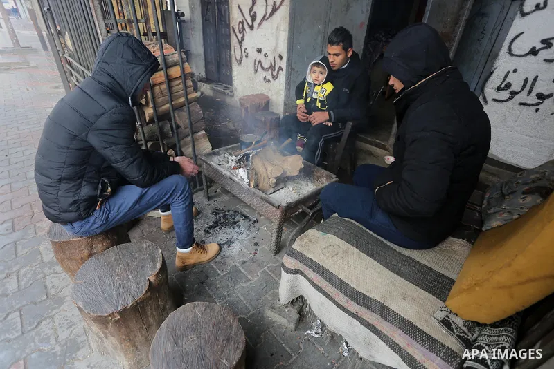 Palestinians warm themselves next to a fire during a winter storm in Gaza city on Jan. 26, 2016. Photo by Mohammed Asad