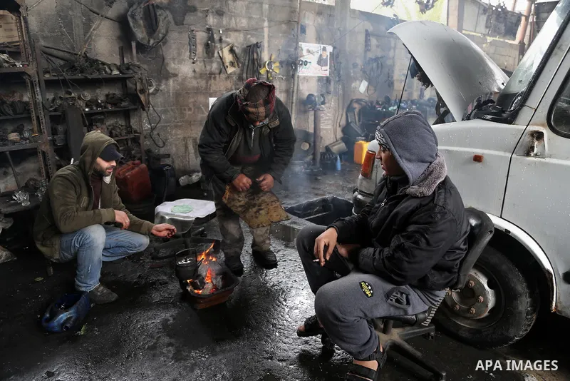 Palestinians warm themselves next to a fire during a winter storm in Gaza city on Jan. 26, 2016. Photo by Mohammed Asad