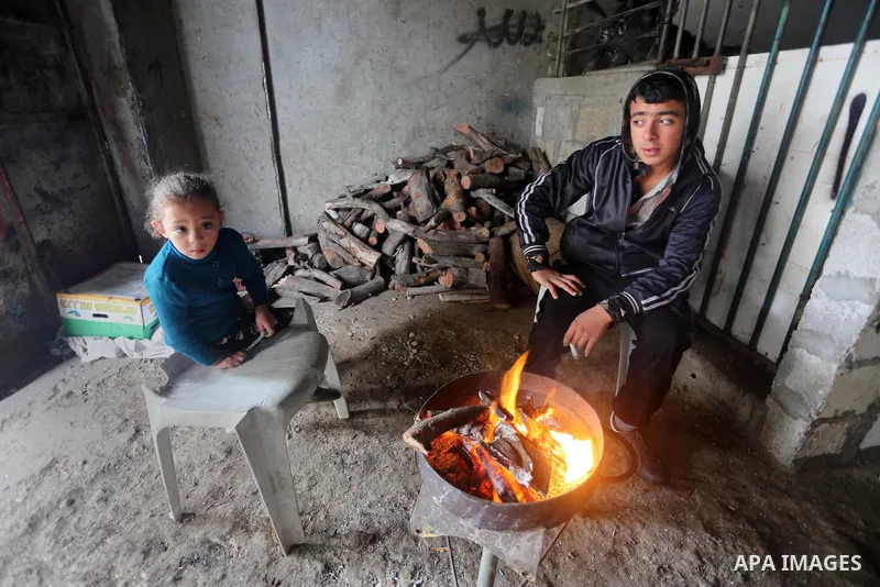 Palestinians warm themselves next to a fire during a winter storm in Gaza city on Jan. 26, 2016. Photo by Mohammed Asad