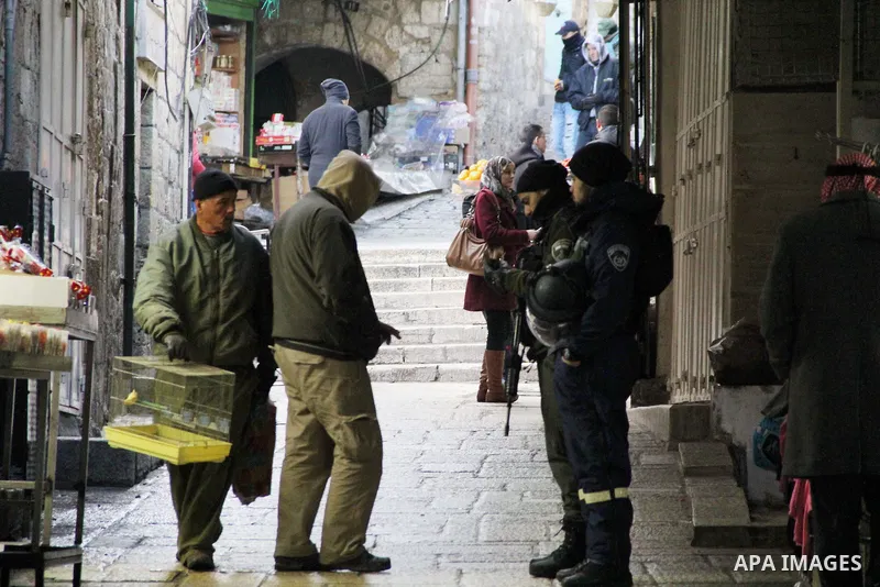 Israeli security forces check the identity cards of a Palestinian man in Jerusalem's Old city on Jan. 26, 2016. Photo by Mahfouz Abu Turk