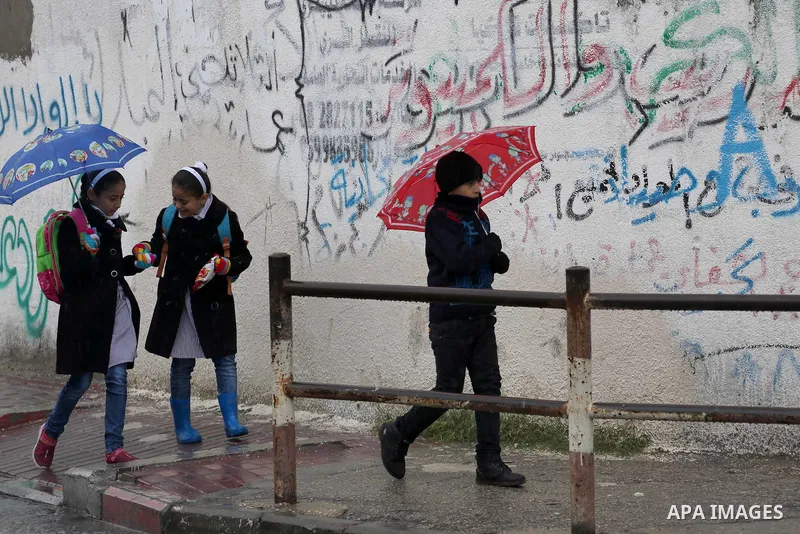 Palestinian students walk with their umbrella under the rain, during a winter storm in Gaza city, on january 27, 2016. Photo by Mohammed Asad
