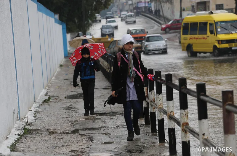 Palestinian students walk with their umbrella under the rain, during a winter storm in Gaza city, on january 27, 2016. Photo by Mohammed Asad