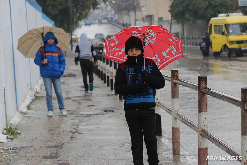 Palestinian students walk with their umbrella under the rain, during a winter storm in Gaza city, on january 27, 2016. Photo by Mohammed Asad