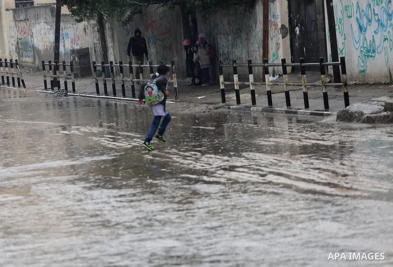 Palestinian students walk with their umbrella under the rain, during a winter storm in Gaza city, on january 27, 2016. Photo by Mohammed Asad