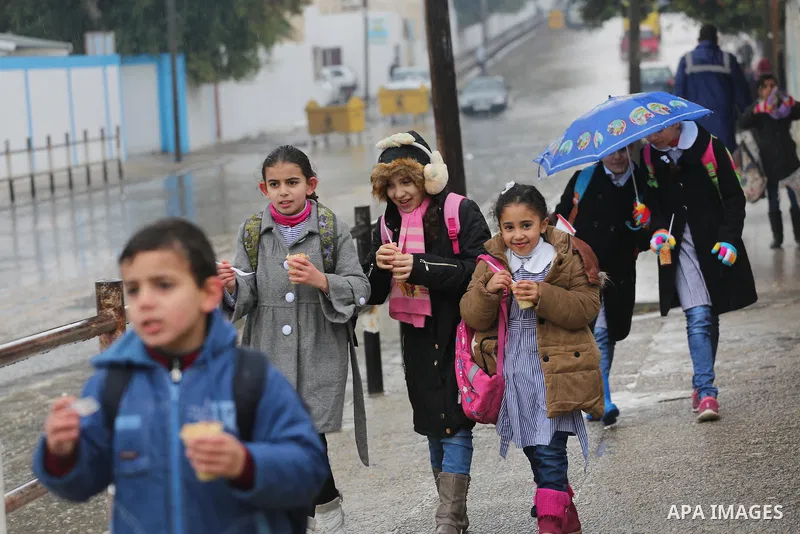 Palestinian students walk with their umbrella under the rain, during a winter storm in Gaza city, on january 27, 2016. Photo by Mohammed Asad