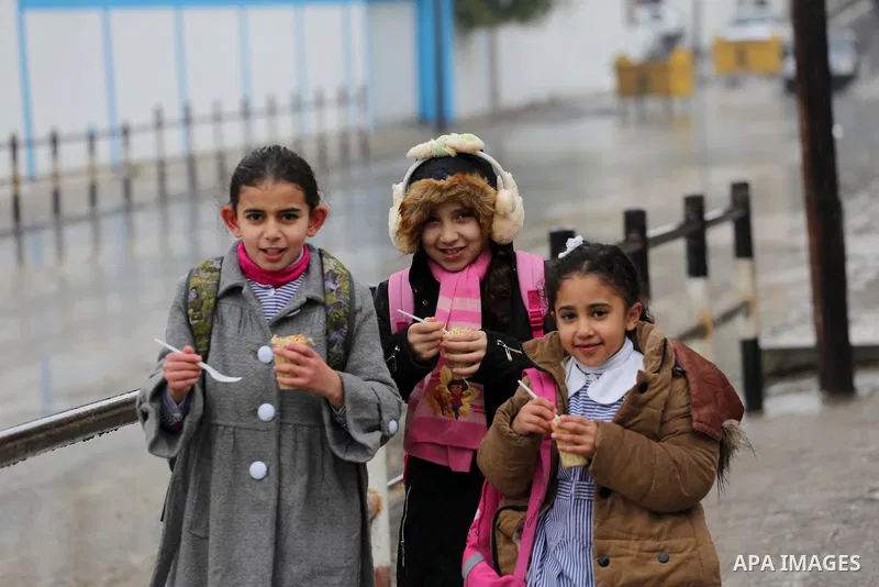 Palestinian students walk with their umbrella under the rain, during a winter storm in Gaza city, on january 27, 2016. Photo by Mohammed Asad