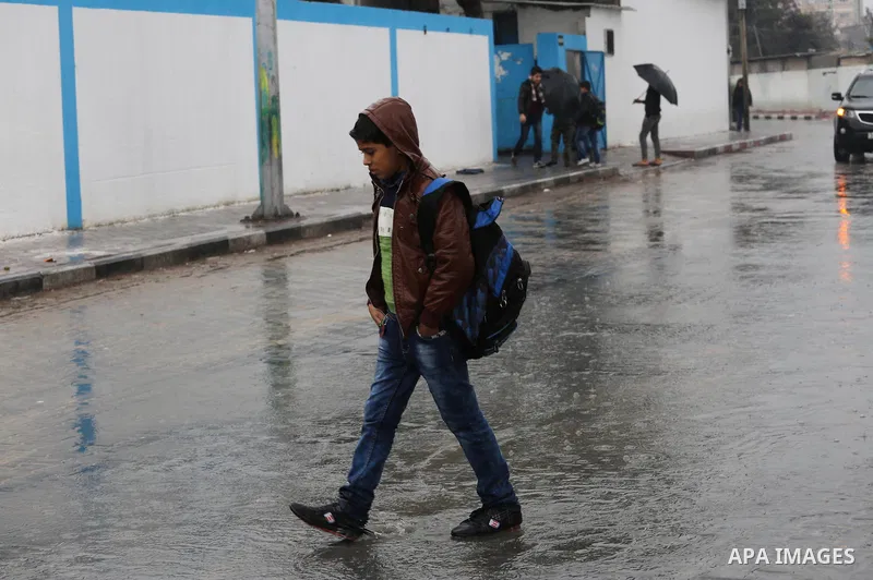 Palestinian students walk with their umbrella under the rain, during a winter storm in Gaza city, on january 27, 2016. Photo by Mohammed Asad