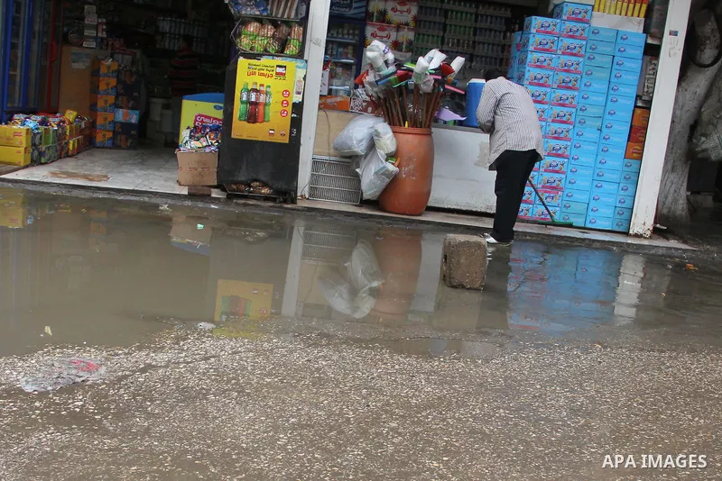 Egyptians walk in a street flooded by rain water, during a winter storm in Cairo, Egypt, on January 27, 2016. Photo by Amr Sayed