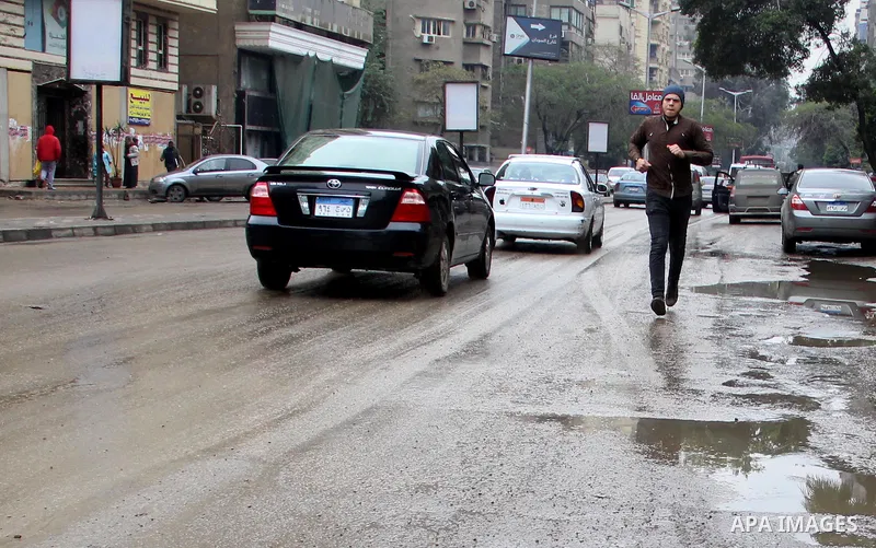 Egyptians walk in a street flooded by rain water, during a winter storm in Cairo, Egypt, on January 27, 2016. Photo by Amr Sayed
