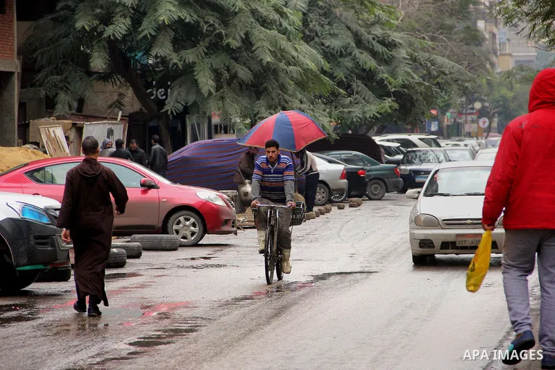 Egyptians walk in a street flooded by rain water, during a winter storm in Cairo, Egypt, on January 27, 2016. Photo by Amr Sayed