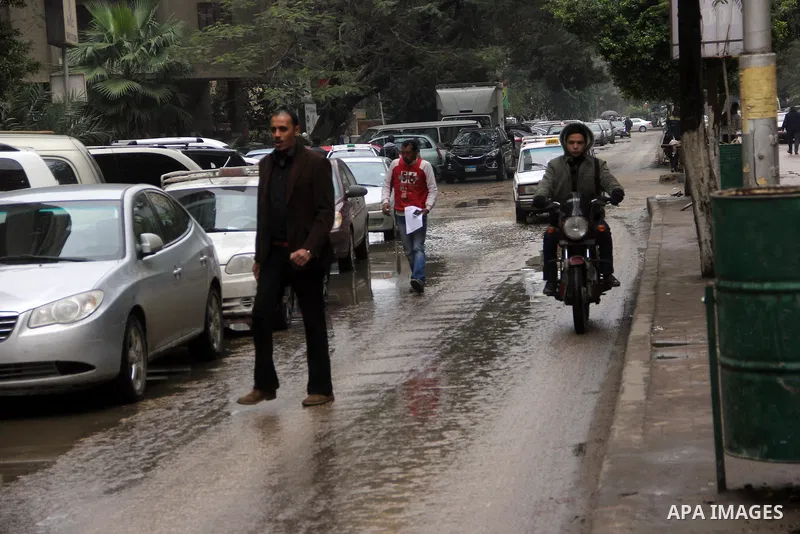 Egyptians walk in a street flooded by rain water, during a winter storm in Cairo, Egypt, on January 27, 2016. Photo by Amr Sayed