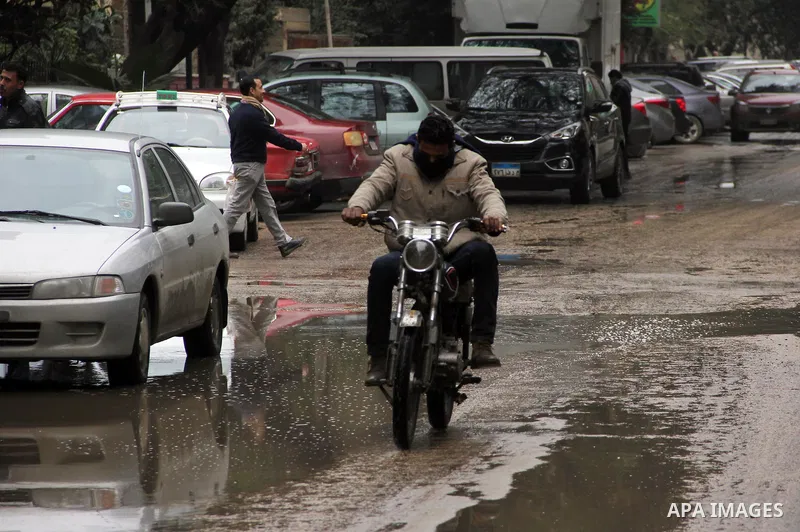 Egyptians walk in a street flooded by rain water, during a winter storm in Cairo, Egypt, on January 27, 2016. Photo by Amr Sayed