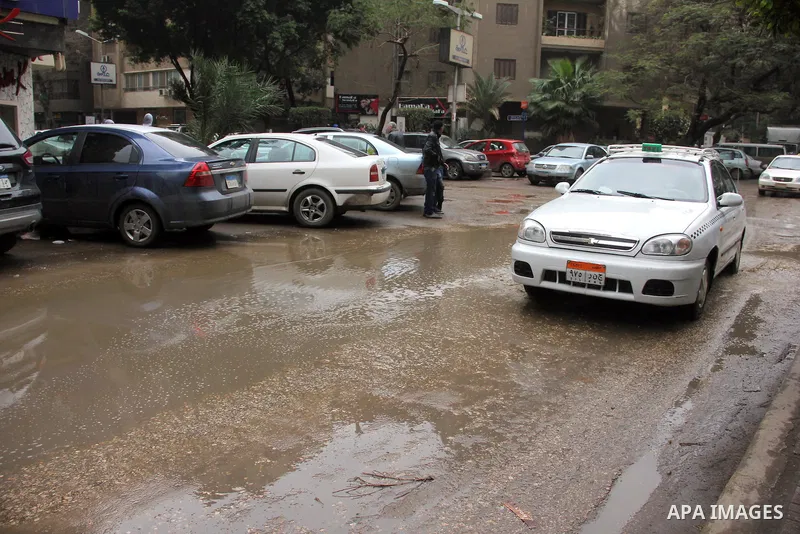 Egyptians walk in a street flooded by rain water, during a winter storm in Cairo, Egypt, on January 27, 2016. Photo by Amr Sayed
