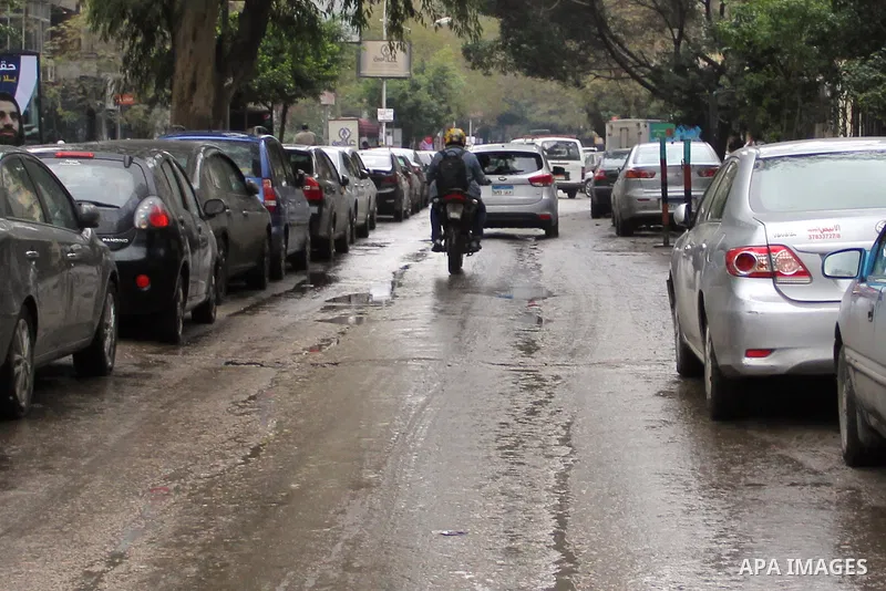 Egyptians walk in a street flooded by rain water, during a winter storm in Cairo, Egypt, on January 27, 2016. Photo by Amr Sayed