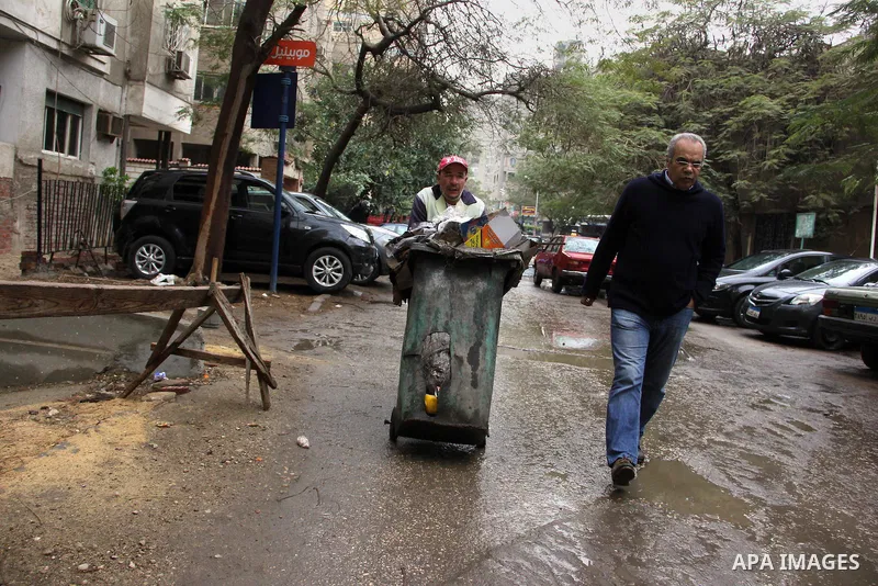 Egyptians walk in a street flooded by rain water, during a winter storm in Cairo, Egypt, on January 27, 2016. Photo by Amr Sayed