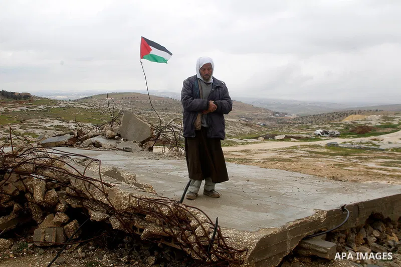 A Palestinian man prays atop the ruins of a mosque, during a snow storm in West Bank village of Mufagara, south of Hebron January 27, 2016. Photo by Wisam Hashlamoun