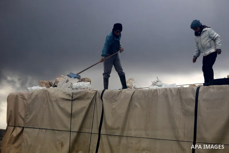 Palestinians remove rainwater from a tent during snow storm in West Bank Village of Mufagara, south of Hebron January 27, 2016. Photo by Wisam Hashlamoun