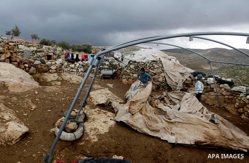 Palestinians stand outside their shed during snow storm in West Bank village of Mufagara, south of Hebron January 27, 2016. Photo by Wisam Hashlamoun