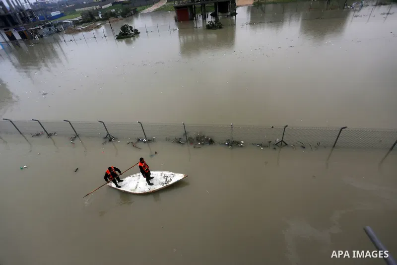 Palestinian Civil Defence workers use a stand-up kayak to evacuate people from a flooded area following heavy rainfall in Rafah in the southern Gaza Strip January 27, 2016. Photo by Yasser Qudih