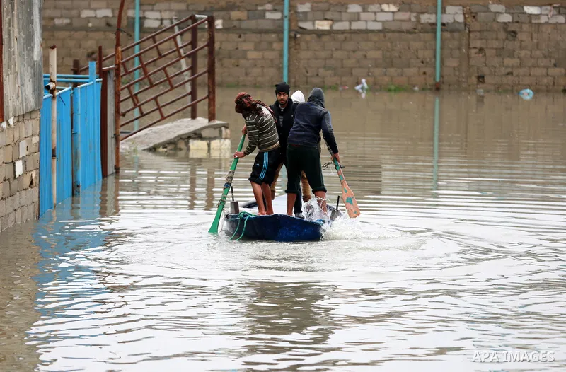 Palestinians paddle a boat in flood waters as they make their way to their flooded chicken farm during a winter storm in Rafah in the southern Gaza Strip January 27, 2016. Photo by Yasser Qudih