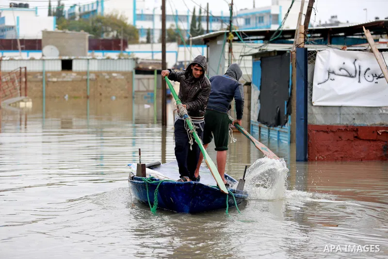 Palestinians paddle a boat in flood waters as they make their way to their flooded chicken farm during a winter storm in Rafah in the southern Gaza Strip January 27, 2016. Photo by Yasser Qudih