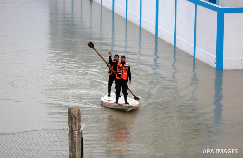 Palestinian Civil Defence workers use a stand-up kayak to evacuate people from a flooded area following heavy rainfall in Rafah in the southern Gaza Strip January 27, 2016. Photo by Yasser Qudih