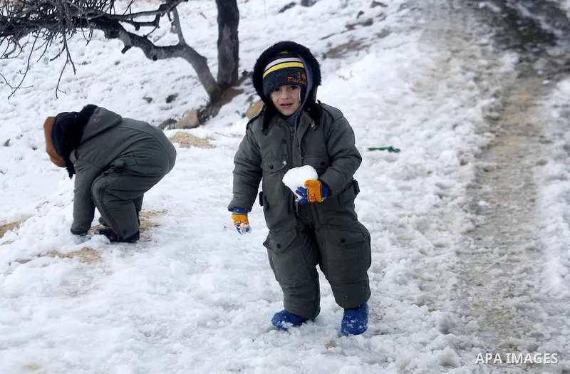 Palestinian children play with snow during a snowstorm in the West Bank town of Halhul, north of Hebron January 27, 2016. Photo by Wisam Hashlamoun
