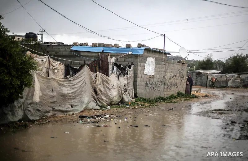 A picture taken on January 25, 2016 shows A Palestinian woman crosses a flooded road following heavy rainfall, in Khan Younis in the southern Gaza Strip. Photo by Mohammed Dahman