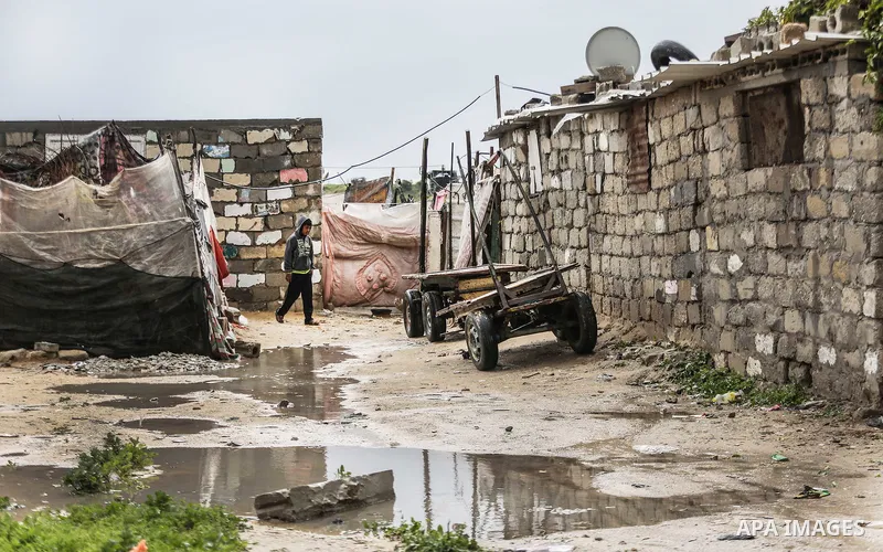 A picture taken on January 25, 2016 shows A Palestinian boy crosses a flooded road following heavy rainfall, in Khan Younis in the southern Gaza Strip. Photo by Mohammed Dahman